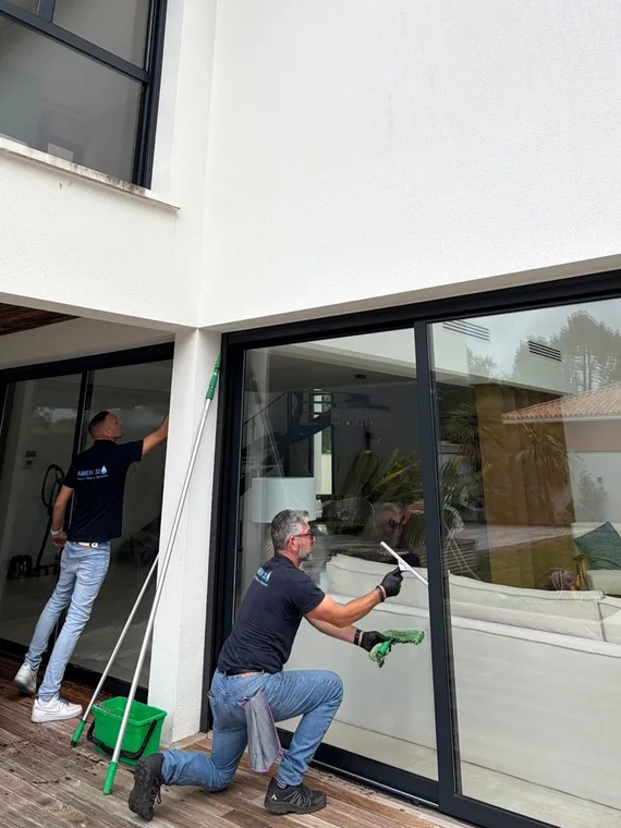 Agents nettoyant les baies vitrées extérieures d'une villa