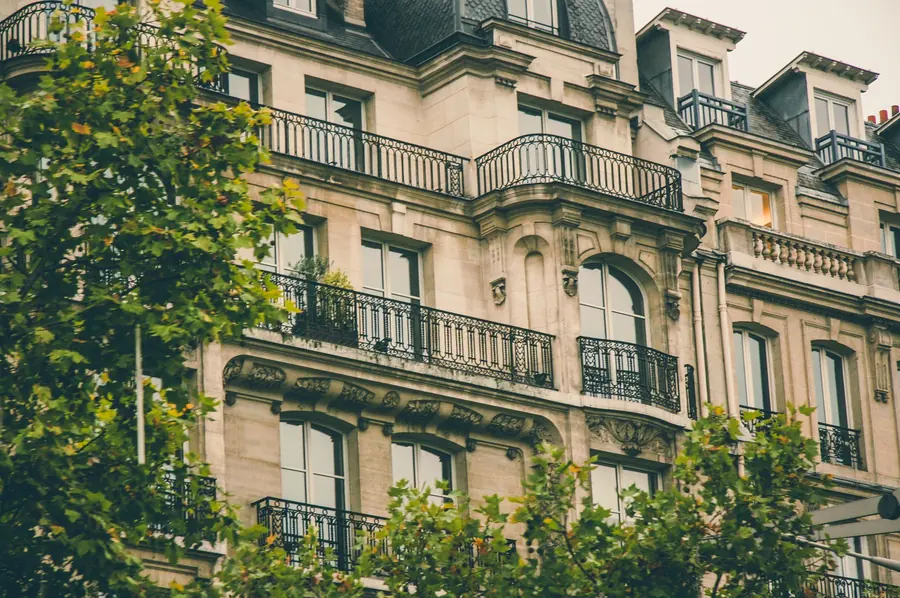 Façade d’immeuble en pierre avec balcons en fer forgé