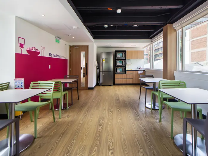 Espace de pause avec tables et cuisine équipée