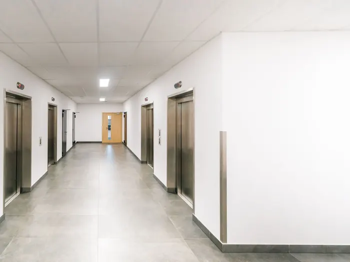 Couloir d’immeuble lumineux devant les ascenseurs