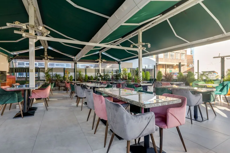 Terrasse de restaurant sous un store vert